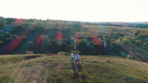 Family Together on Green Hilltop Overlooking Scenic Valley