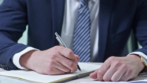 Geschäftsmann schreibt im Notizbuch