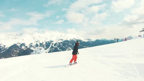 Rear View Athlete Snowboarder Ride Down Slope Hill on Snowboard and Performs Maneuverable Movements