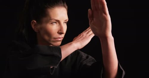 Woman Practices Karate in Black Uniform