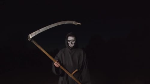 Scary Figure Holding a Scythe in the Dark