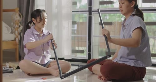 Girl and Woman Assemble Furniture Together at Home