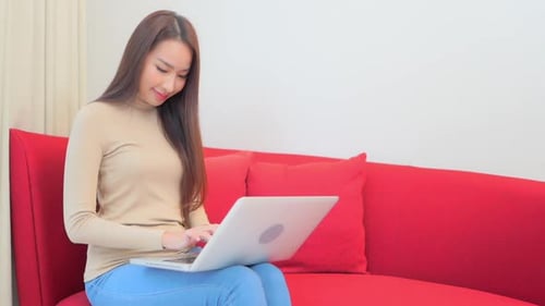 Woman Works on Laptop While Sitting on Couch