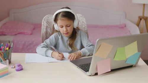 Girl Studies at Desk with Laptop and Headphones