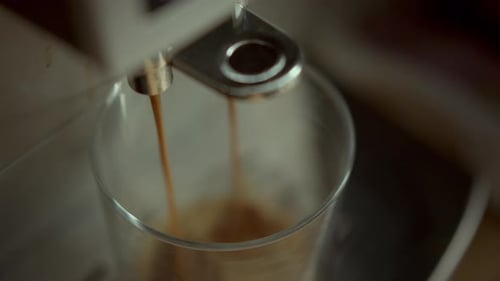 Espresso Being Poured into Clear Glass Close Up