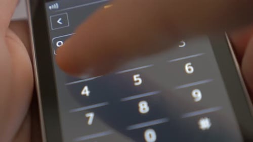 Hand Entering Numbers on Cell Phone Touchscreen