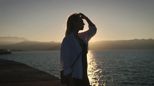 Silhouette of a Slender Young Woman Against the Setting Sun