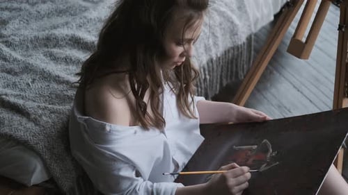 Portrait of a Girl Artist Working on a Painting in a Home Studio