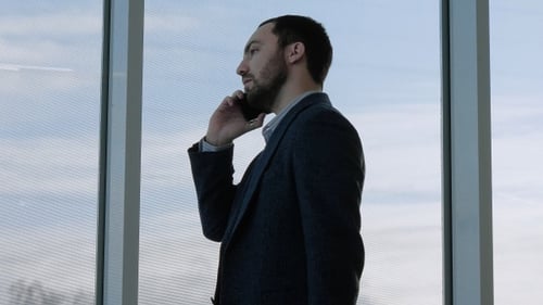 Man Talking on Phone by Large Window