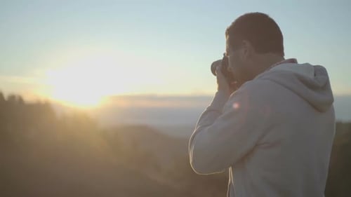 Junger Mann in der Natur Berg im Freien Fotos mit Kamera bei Sonnenaufgang oder Sonnenuntergang in Zeitlupe