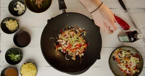 Professional Cook Frying Vegetables with Noodles
