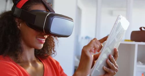 Seitenansicht einer amerikanischen afrikanischen Modedesignerin mit Virtual-Reality-Headset und digitalem Tisch