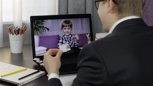 Man Video Conferencing with Child on Laptop