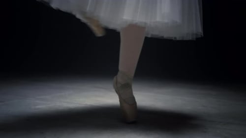 Elegant Ballerina Dancing on Pointe in a Dark Studio