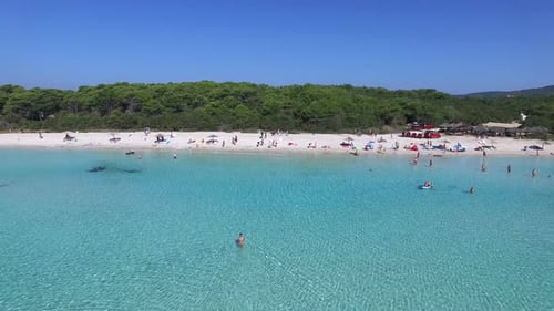 People swimming and sunbathing on a mediterranean beach