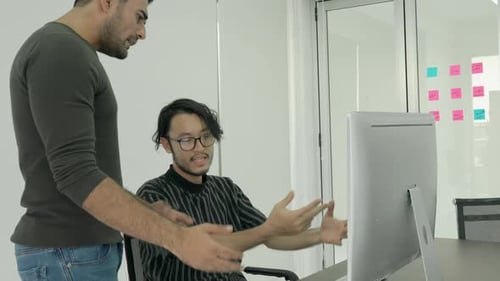Men Discussing Work Around a Computer in Office