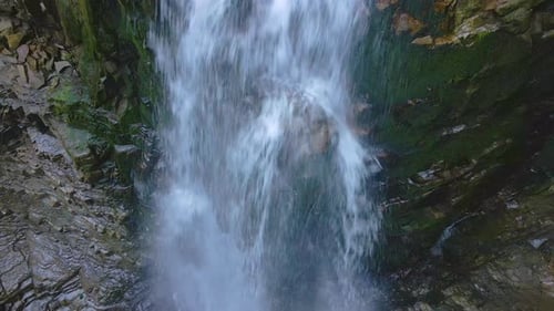 Waterfall on Mountain River with White Foamy Water Falling Down From Rocky Formation in Summer