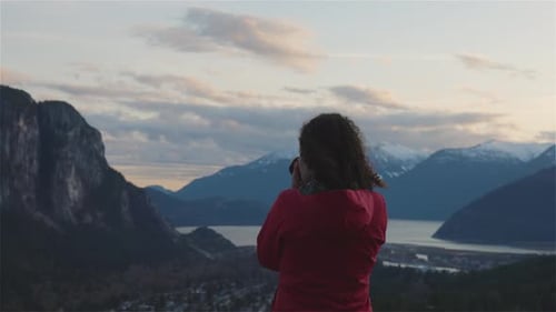 Woman Taking Photo of Beautiful Mountain Landscape