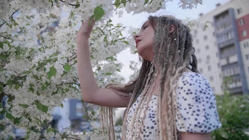 Young Woman Enjoys Spring Blossoms in the City