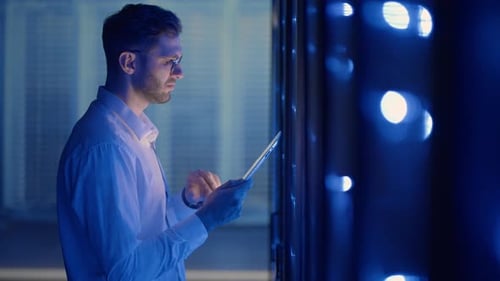 IT Technician in Data Center Digital Server Room Controlling Work of Rack Server Cabinets with a