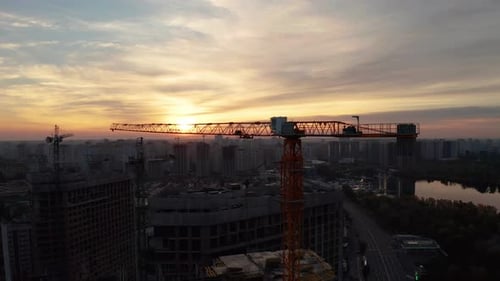 Chantier avec grues au coucher du soleil