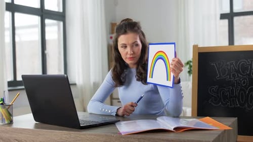 Cheerful Teacher Giving Online Lesson With Rainbow Drawing