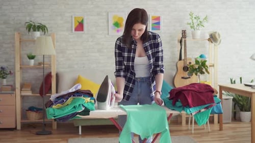 Woman Ironing Clothes in Living Room