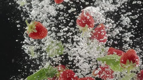 Strawberry Beautiful Falling ins Wasser in Zeitlupe auf schwarzem Hintergrund