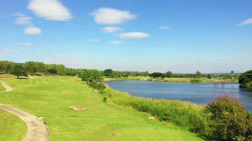 4K Aerial view of golf course with green lawn fairway and trees in summer sunny day