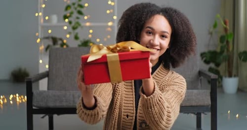Woman Presents Gift in Cozy Home Setting