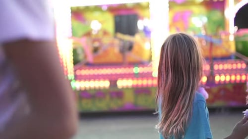 La niña se divierte en la feria con luces.