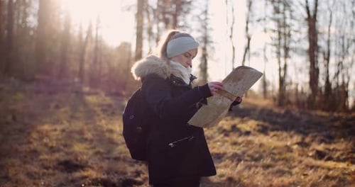 Woman Hiker Reading a Map in Forest