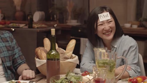 Friends Play Party Game Together at Dinner Indoors