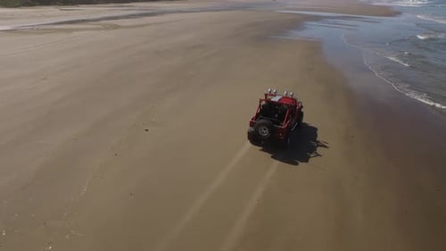 Aerial shot of 4x4 off road vehicle driving on beach