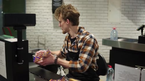 Cashier Scanning Items at Checkout Station