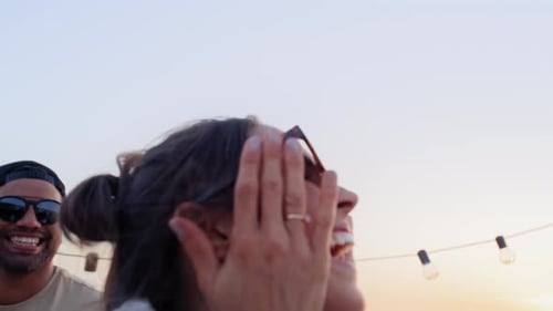 Friends Dancing on Rooftop at Sunset