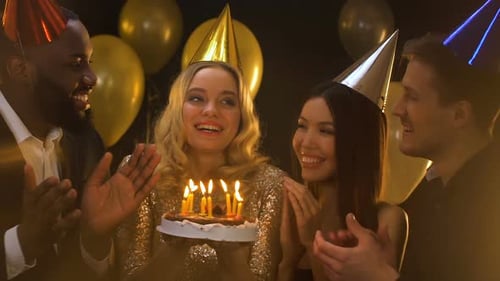 Friends Celebrate Birthday by Blowing out Cake Candles