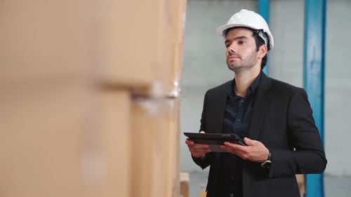 Factory Manager Using Tablet Computer in Warehouse or Factory