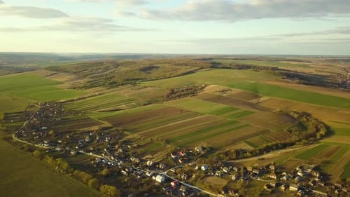 Aerial view of countryside village with small houses among green trees