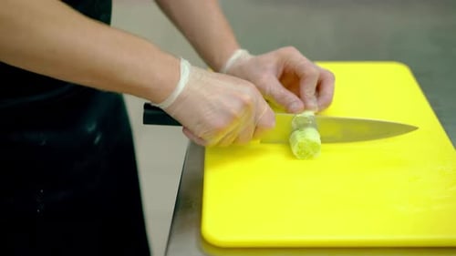 CU Cook corta muy rápidamente un pepino fresco en rodajas redondas con un cuchillo