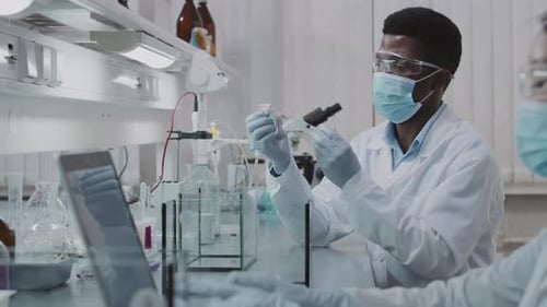 Man Prepares Syringe in Bright Research Laboratory