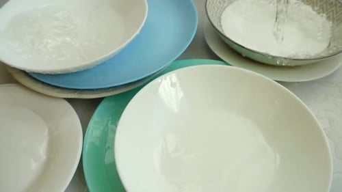 Water Poured Into Stack of Colorful Plates