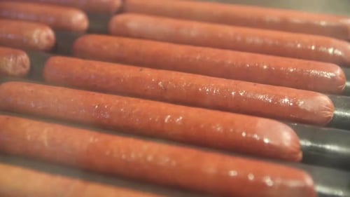 Natural Sausages Heating on Modern Stove in Fastfood Cafe