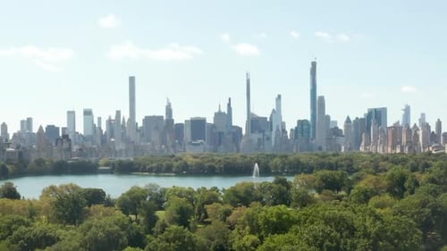 AERIAL: Beautiful Central Park View and Manhattan Skyline in Background at Sunny Summer Day