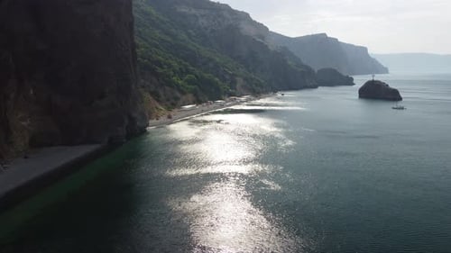 Luftbild von oben auf ruhiges azurblaues Meer und vulkanische Felsküsten