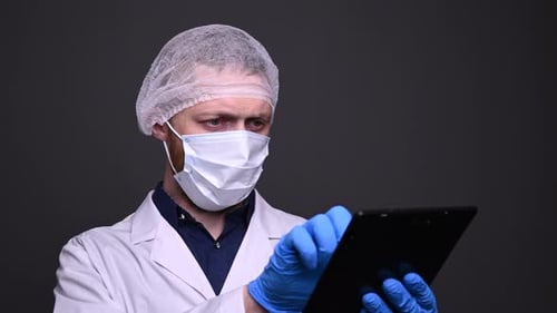 Close-up of male doctor is swiping the tablet. Hard work of medical staff