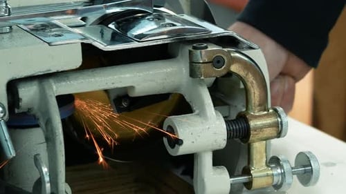 Worker Sharpening a Blade on a Skiving Machine. Adjusting Automatic Leather Skiving Machine in a