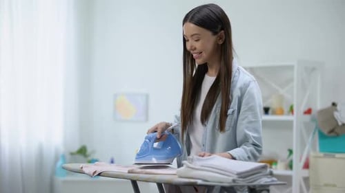 Smiling Woman Ironing Laundry at Home