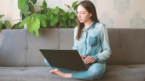 Woman Using Laptop Sitting Cross-Legged on Couch