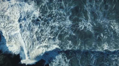 Dramático olas del océano que chocan a cámara lenta sobre las rocas disparadas de arriba Zumbido abajo